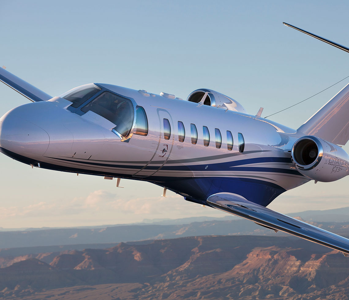Cessna Citation CJ3 private jet flying over canyon