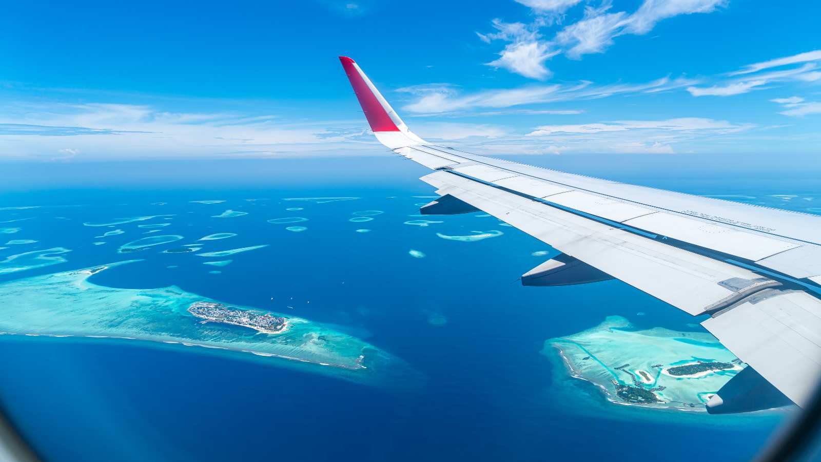 Maldives islands top view from airplane window with airplane
