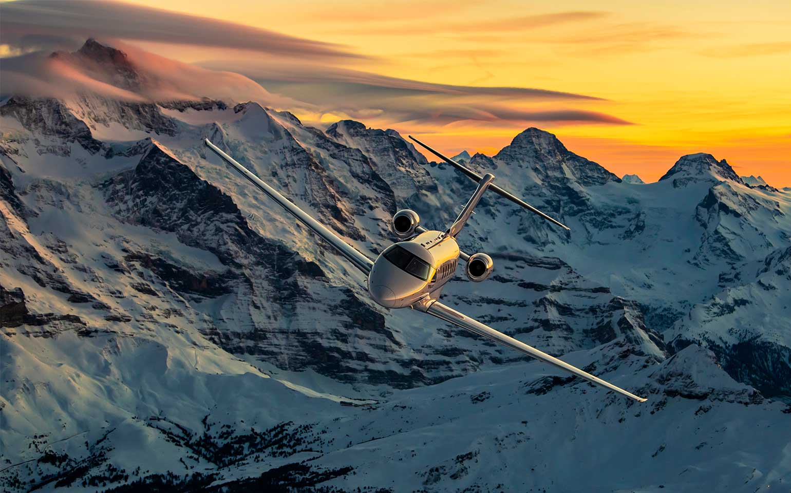 Pilatus PC-24 jet flying by snow-covered mountains